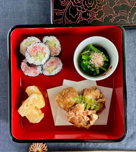 Sushi and karaage and side dishes in a traditional Wajima lacquer box